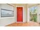 Inviting front porch with red door and tile flooring, offering a welcoming entrance to the residence at 3032 Parkway Blvd # 302, Kissimmee, FL 34747