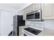 Functional kitchen with stainless steel refrigerator, and electric range, and white cabinetry offering ample storage at 3032 Parkway Blvd # 302, Kissimmee, FL 34747