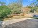 Spacious backyard with a large paved patio, mature trees, wooden fence, and boat trailer at 3692 Okeechobee Cir, Casselberry, FL 32707
