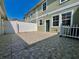 A backyard featuring a paved patio, complemented by a green exterior wall and white trim at 7128 Five Oaks Dr, Harmony, FL 34773