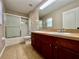 Bathroom featuring a shower and bathtub combination with sliding glass doors and a double sink vanity, providing ample space at 7128 Five Oaks Dr, Harmony, FL 34773