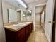 Bathroom featuring a double sink vanity and tile flooring with an adjacent room creating a practical and functional layout at 7128 Five Oaks Dr, Harmony, FL 34773