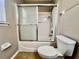 Bathroom featuring a shower and bathtub combination with sliding glass doors, and a toilet at 7128 Five Oaks Dr, Harmony, FL 34773