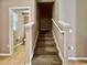 Carpeted staircase leading upstairs, with a partial view of the bathroom at 7128 Five Oaks Dr, Harmony, FL 34773