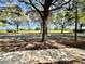 Street view with sidewalk, trees, and a glimpse of a golf course in the background at 7128 Five Oaks Dr, Harmony, FL 34773