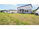 Expansive backyard featuring well-maintained lawn and a covered patio, perfect for outdoor gatherings at 2949 Wild Olive Dr, St Cloud, FL 34772
