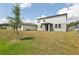 Spacious backyard, highlighting the home's exterior and covered patio on a sunny day at 2949 Wild Olive Dr, St Cloud, FL 34772