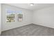 Spacious bedroom is bathed in natural light with two windows offering neighborhood views and plush carpeting at 2949 Wild Olive Dr, St Cloud, FL 34772