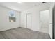 Bright bedroom features soft gray carpet, closet, and a window bringing in natural light at 2949 Wild Olive Dr, St Cloud, FL 34772