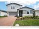 Charming two-story home features a brick driveway, gray siding, and well-maintained landscaping at 2949 Wild Olive Dr, St Cloud, FL 34772