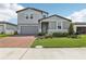 Charming two-story home boasts a well-manicured lawn, brick driveway, and attached garage at 2949 Wild Olive Dr, St Cloud, FL 34772