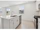 Bright kitchen boasts all-white cabinets, stainless appliances, an island with sink and backyard view at 2949 Wild Olive Dr, St Cloud, FL 34772