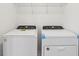 Bright laundry room featuring a new white washer and dryer with overhead storage at 2949 Wild Olive Dr, St Cloud, FL 34772