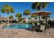 Relaxing pool area with patio furniture and palm trees at 3171 Paradox Cir # 305, Kissimmee, FL 34746