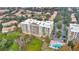 Aerial view of waterfront condominium featuring a pool, parking, and verdant landscape at 6336 Buford St # 705, Orlando, FL 32835