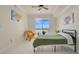 Bedroom with tile floors, ceiling fan, bed, yellow chair, and sliding glass doors to a balcony with a waterfront view at 6336 Buford St # 705, Orlando, FL 32835