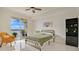 Bedroom with tile floors, ceiling fan, bed, yellow chair, and sliding glass doors to a balcony with a waterfront view at 6336 Buford St # 705, Orlando, FL 32835