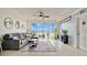 Bright living room with a gray sectional sofa, ceiling fan, rug, and sliding glass doors to balcony with a waterfront view at 6336 Buford St # 705, Orlando, FL 32835