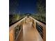 A wooden walkway leads through the property to an outdoor venue at night with landscape lighting at 6336 Buford St # 705, Orlando, FL 32835