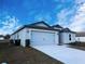 Side view of the house showing the driveway, two-car garage, and landscaping at 1123 Union Ave, Mascotte, FL 34753