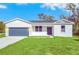 Newly built home with a gray garage door and green lawn at 139 Malauka Pass, Ocklawaha, FL 32179