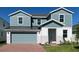 Two-story home featuring blue siding, a brick walkway, a gray garage door, and well-maintained landscaping at 2059 Town Pasture Dr, Eustis, FL 32726