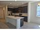 Modern kitchen featuring dark cabinetry, stainless steel appliances, and a spacious center island at 2063 Town Pasture Dr, Eustis, FL 32726