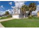 Inviting two-story home featuring an attached garage, verdant lawn, and mature palm trees at 3279 Fairfield Dr, Kissimmee, FL 34743