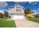 Two-story house with gray siding, white garage door, and palm trees at 3279 Fairfield Dr, Kissimmee, FL 34743
