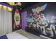 Playful bedroom with vibrant Toy Story-themed decor, TV, rocket accents, and custom artwork at 4294 Lana Ave, Davenport, FL 33897