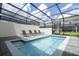 Screened-in pool area featuring lounge chairs, clear blue water, and sunny backyard views at 4294 Lana Ave, Davenport, FL 33897