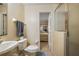 Bathroom with toilet, sink, and shower, plus view into bedroom at 6900 Sw 137Th Court Rd, Ocala, FL 34481