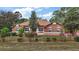 One-story home with brown exterior, landscaped yard, and driveway at 6900 Sw 137Th Court Rd, Ocala, FL 34481