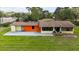 The front exterior of the home with a grassy yard and a mix of yellow and orange paint at 11326 Westwood Blvd, Orlando, FL 32821