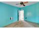 Turquoise bedroom with ceiling fan, peeling wall and old carpet at 14025 Royal Fern Way, Astatula, FL 34705