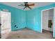 Turquoise bedroom featuring a ceiling fan and doorways to other rooms of the house at 14025 Royal Fern Way, Astatula, FL 34705