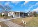 Street view of a light yellow single-story home with a screened-in carport at 14025 Royal Fern Way, Astatula, FL 34705