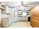 Outdated kitchen with wallpaper, wood cabinets, laminate counters and a small window at 14025 Royal Fern Way, Astatula, FL 34705