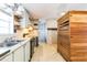 Outdated kitchen with wallpaper, wood cabinets, laminate counters and a small window at 14025 Royal Fern Way, Astatula, FL 34705