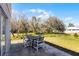 Back patio features outdoor seating with a table and four chairs surrounded by lush greenery at 1907 Lakeview Way, Kissimmee, FL 34759
