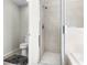 Bathroom featuring a tiled walk-in shower with glass door, a toilet, and updated fixtures at 1907 Lakeview Way, Kissimmee, FL 34759