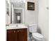 View of the bathroom with a framed painting, marble countertops, and a glimpse into the laundry area at 1907 Lakeview Way, Kissimmee, FL 34759