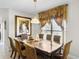 Formal dining room with a large wooden table, upholstered chairs, and an elegant window treatment at 1907 Lakeview Way, Kissimmee, FL 34759
