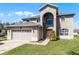 Two-story home boasting an attached garage, well-manicured lawn, and an arched entryway with a large window at 1907 Lakeview Way, Kissimmee, FL 34759