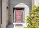 Close-up view of a stately, red front door framed by sidelights and elegant exterior lighting at 1907 Lakeview Way, Kissimmee, FL 34759