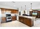 Open kitchen with a central island, wood cabinets, and modern appliances at 1907 Lakeview Way, Kissimmee, FL 34759