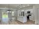 Bright open kitchen with stainless steel appliances, white cabinets, and island with pendant lights at 350 Marion Oaks Pass, Ocala, FL 34473