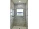 Stylish shower with marble-look tile and modern black fixtures, creating a luxurious feel at 350 Marion Oaks Pass, Ocala, FL 34473