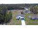 Aerial view of a modern home with a dark roof and a long driveway surrounded by trees at 559 Marion Oaks Blvd, Ocala, FL 34473