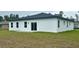 The backyard shows the home's exterior, windows, sliding glass door, and green grass at 559 Marion Oaks Blvd, Ocala, FL 34473